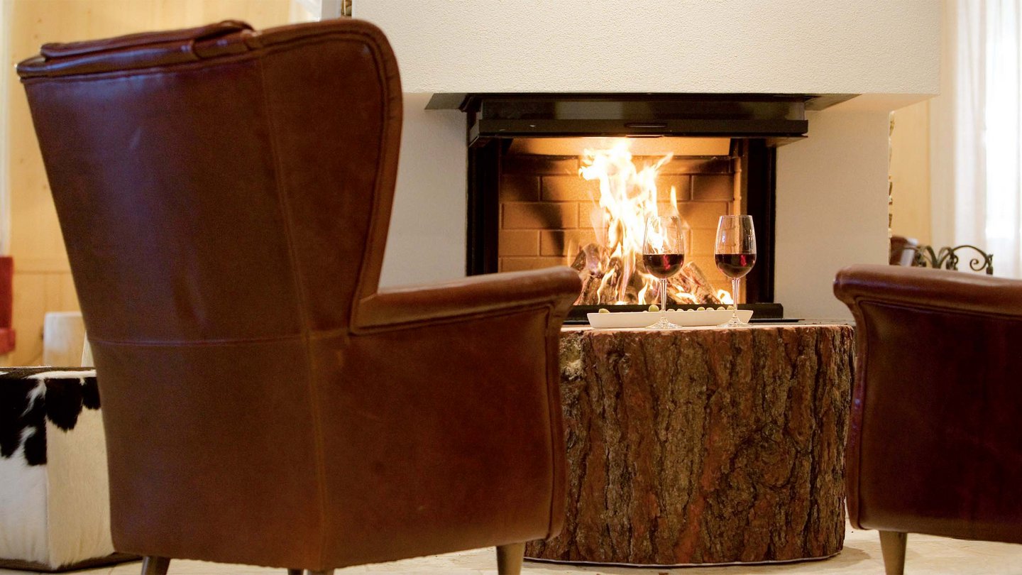 Cozy armchairs by the fireplace in the lounge of Family Hotel Bella Vista, Trafoi.