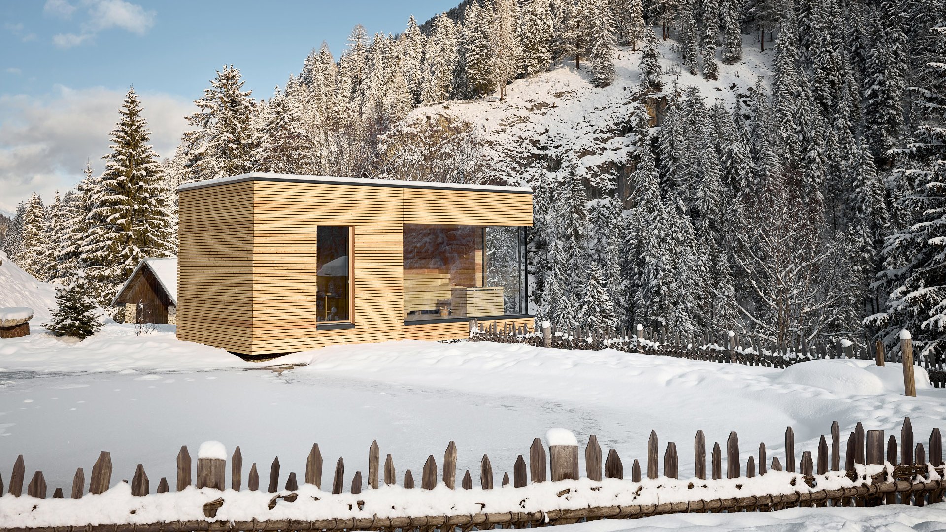 Outdoor sauna featuring modern architecture style of the wellness area, nestled in a winter landscape with snow-covered trees and a mountain in the background.