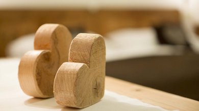 Due cuori di legno su un supporto, che irradiano amorevole artigianalità e bellezza naturale.